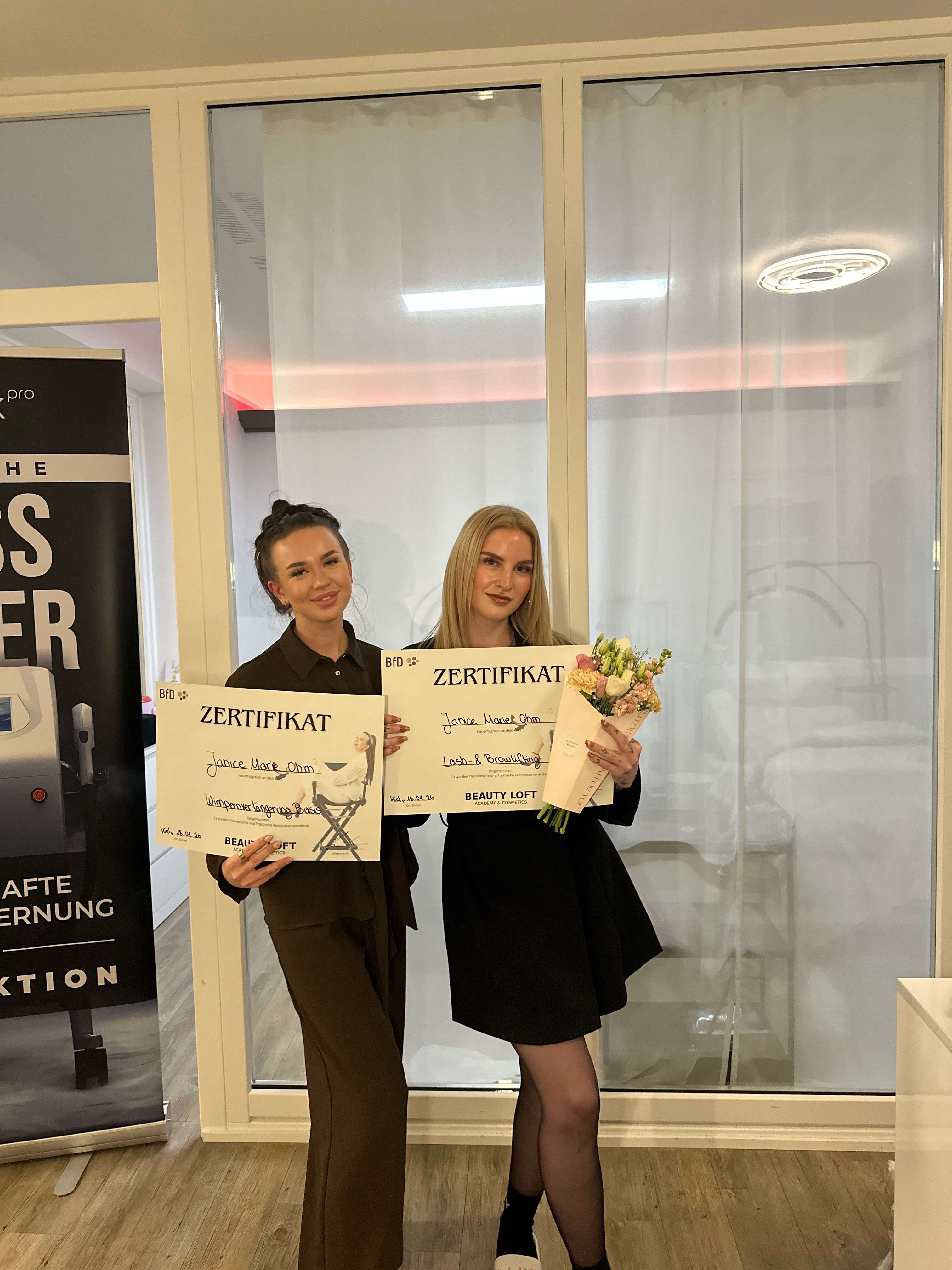 Absolventinnen mit Zertifikaten und Blumen